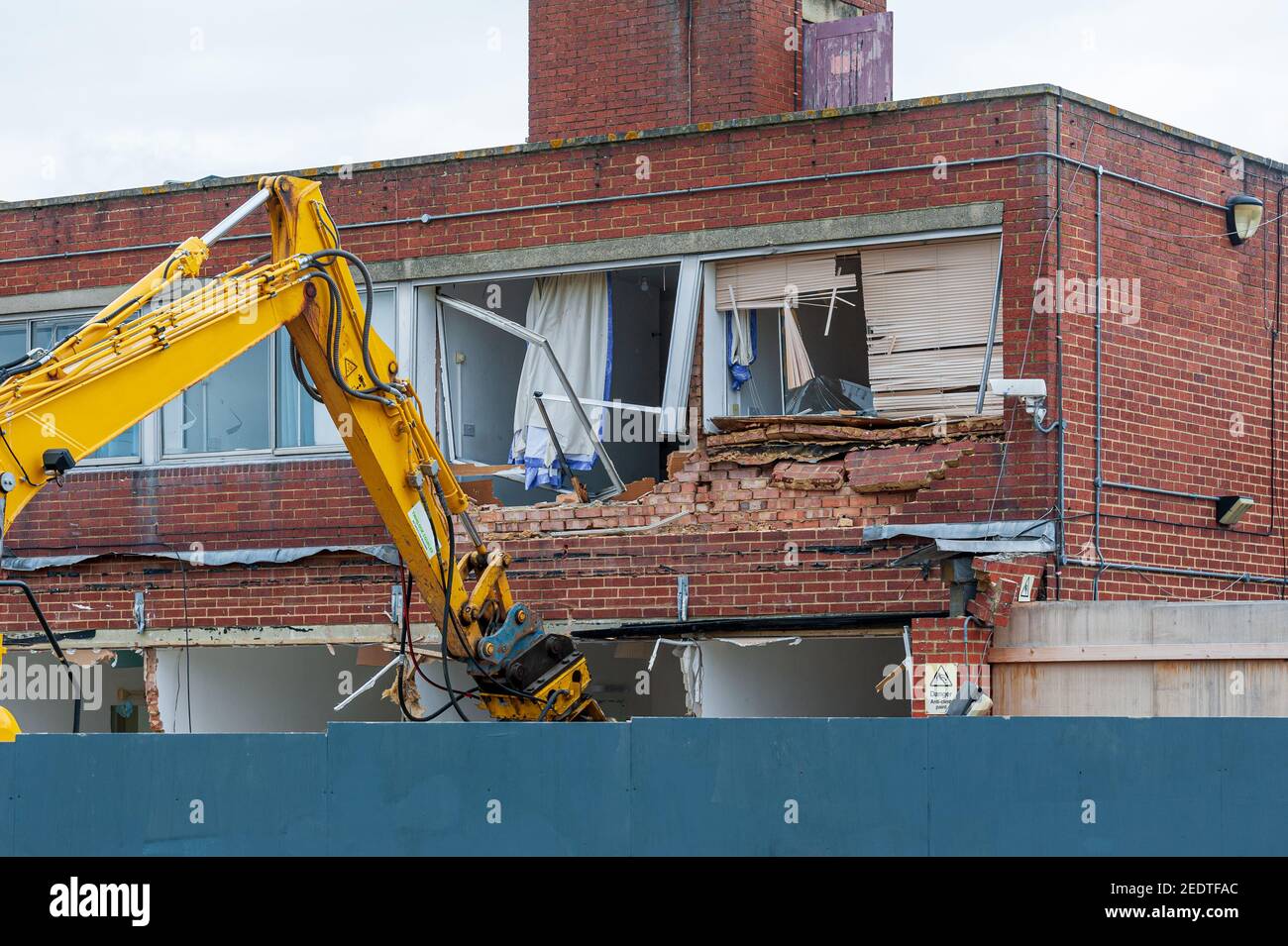 Demolition of an old building with a long reach machine hydraulic jaw. Regeneration of a space for new, modern building. Stock Photo