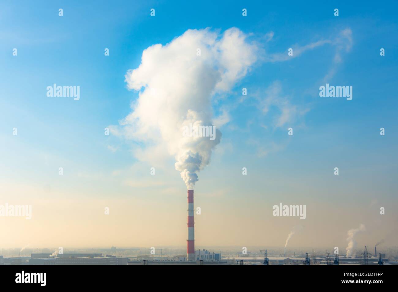 Smoke from the pipe CHP a blue day sky. Ambient air pollution environmental industrial emissions Stock Photo