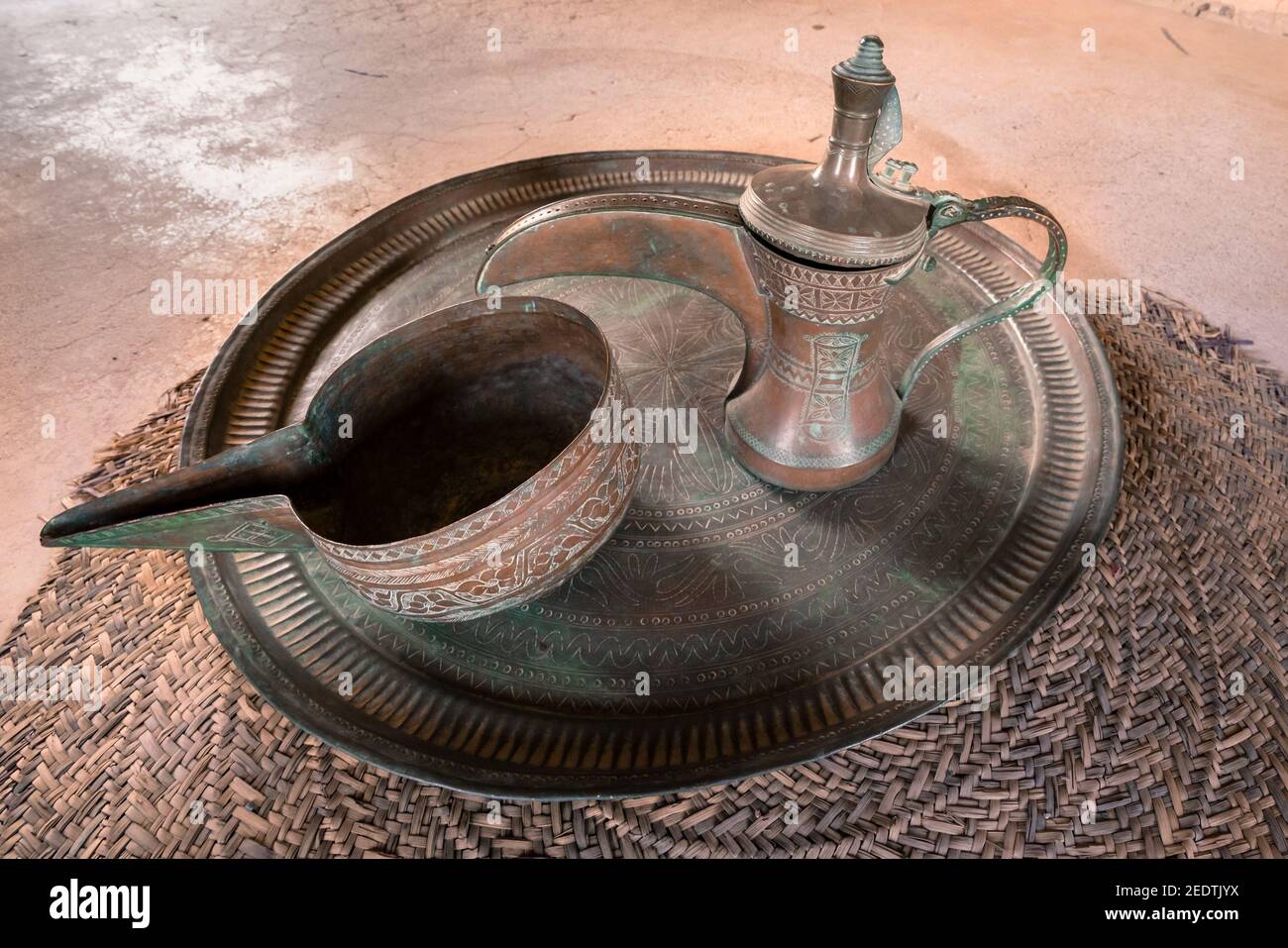 Vintage Brass Ornate Arabic Dallah. Metal tea pot on a metal plate. Stock Photo