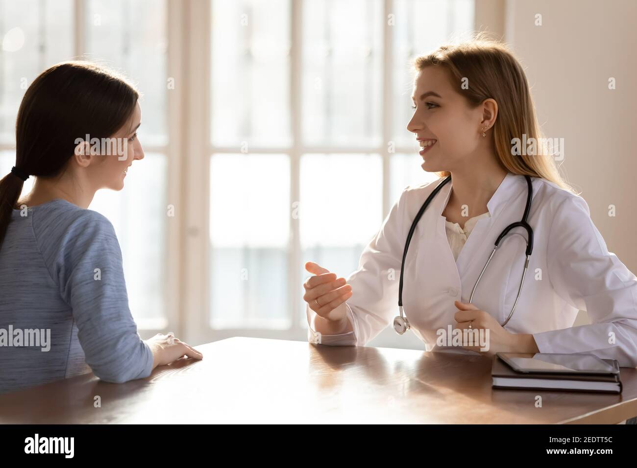 Happy woman enjoying checkup visit with doctor. Stock Photo