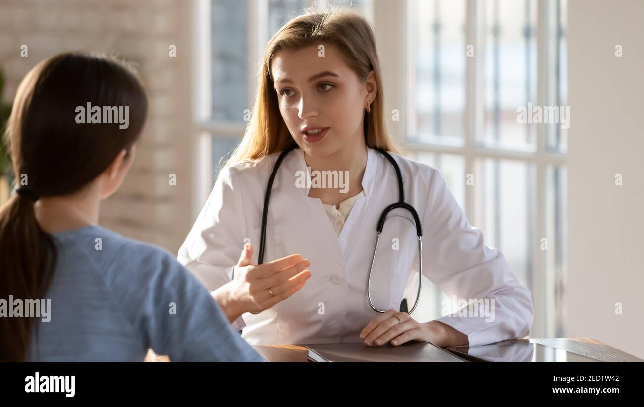 Focused young beautiful female doctor talking with patient Stock Photo ...