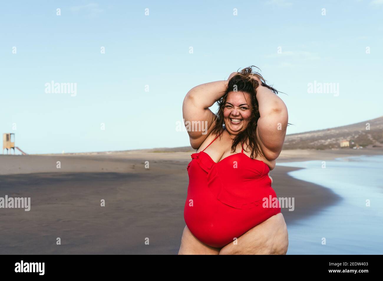 Happy plus size woman posing on the beach - Curvy overweight model having  fun during vacation in tropical destination Stock Photo - Alamy