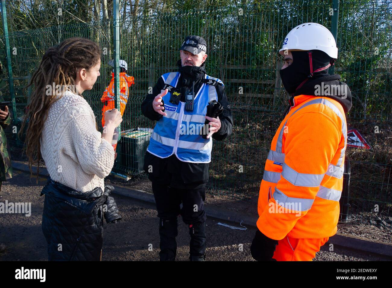 Wendover, Buckinghamshire, UK. 15th February, 2021. An activist asks a Police Liaison Officer why HS2 have confiscated her personal belongings and not returned them. HS2 Ltd have this morning fenced off a public footpath and started fencing off an area of woodland known as the Spinney in readiness to fell numerous mature trees as part of the High Speed 2 rail link from London to Birmingham. The landowner was allegedly not notified by HS2 Ltd in advance. National Eviction Team (NET) bailiffs working for HS2 were on site as were a large number of police who were using a drone above the woods. An Stock Photo