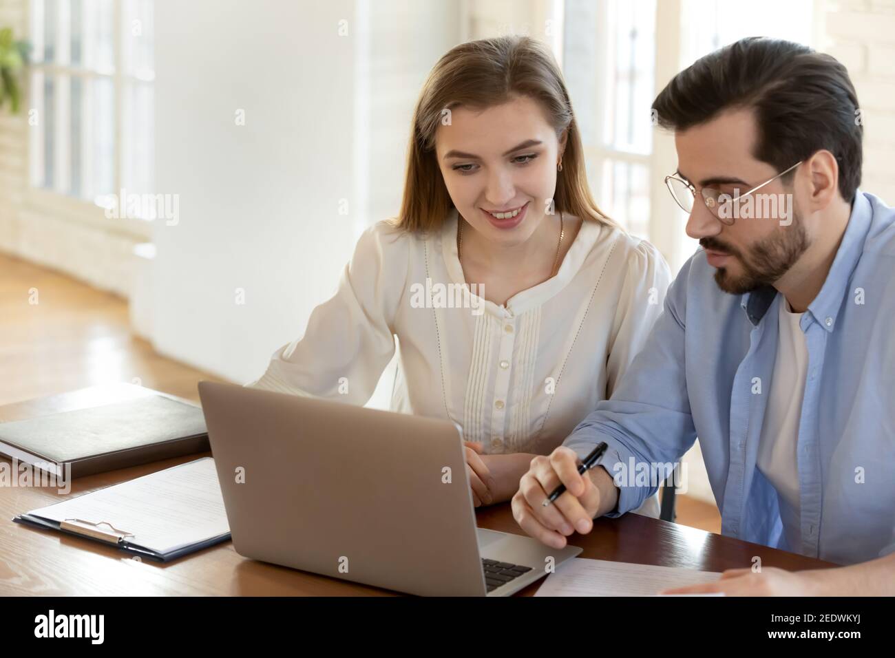 Happy two colleagues working together on computer. Stock Photo