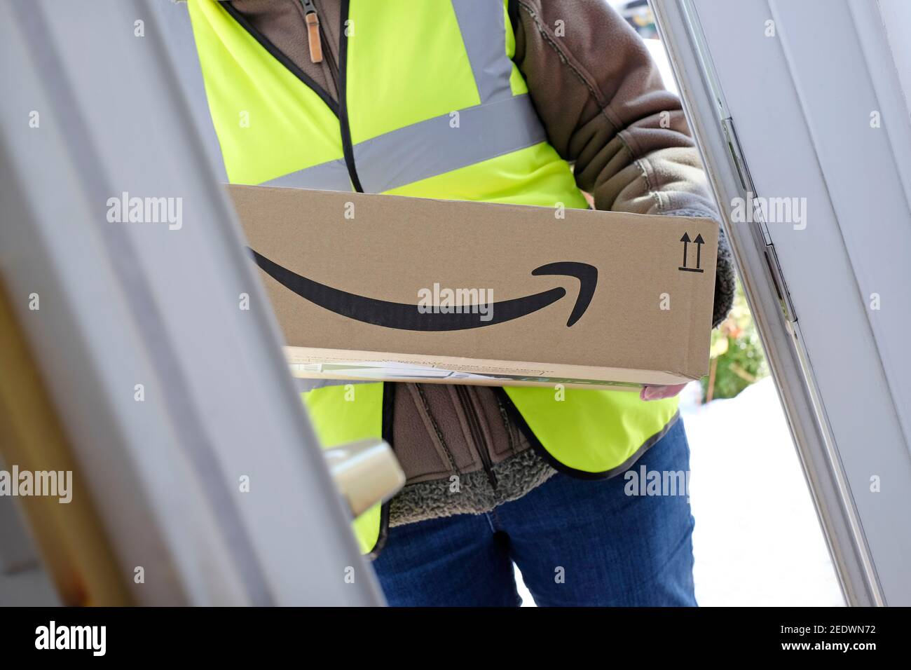 person delivering amazon parcel at front door, norfolk, england Stock Photo