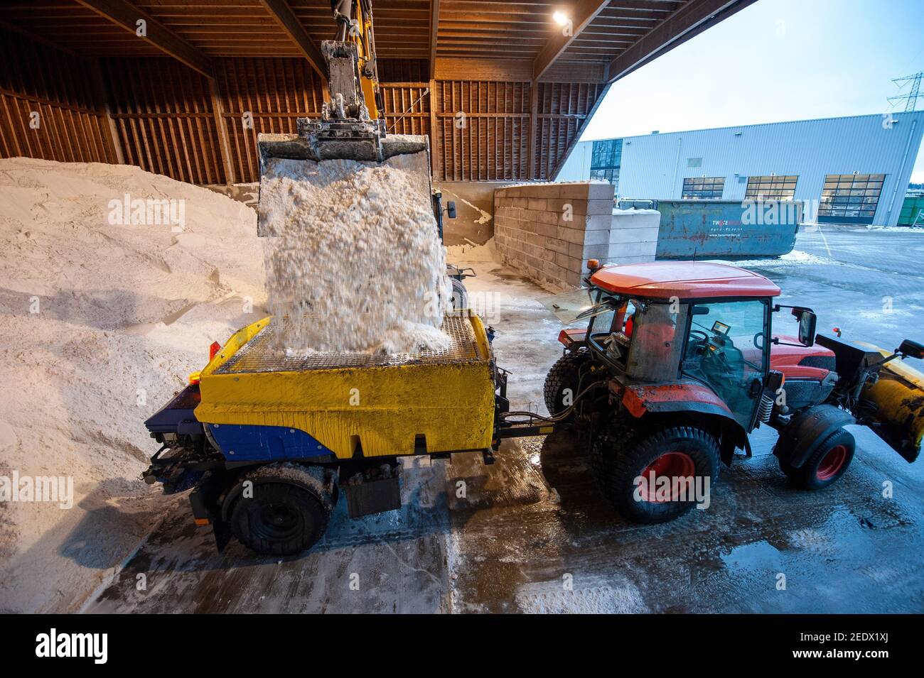 An excavator at work in a salt storage used for anti skidding on a road. Stock Photo