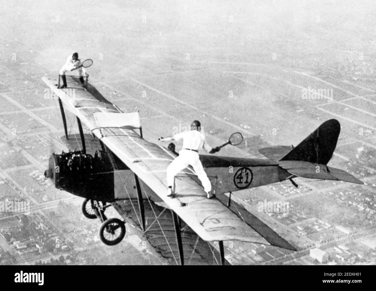 STUNT  Gladys Roy (at left) and Ivan Unger pretend to play tennis in 1925 during an aerial stunt show. Stock Photo
