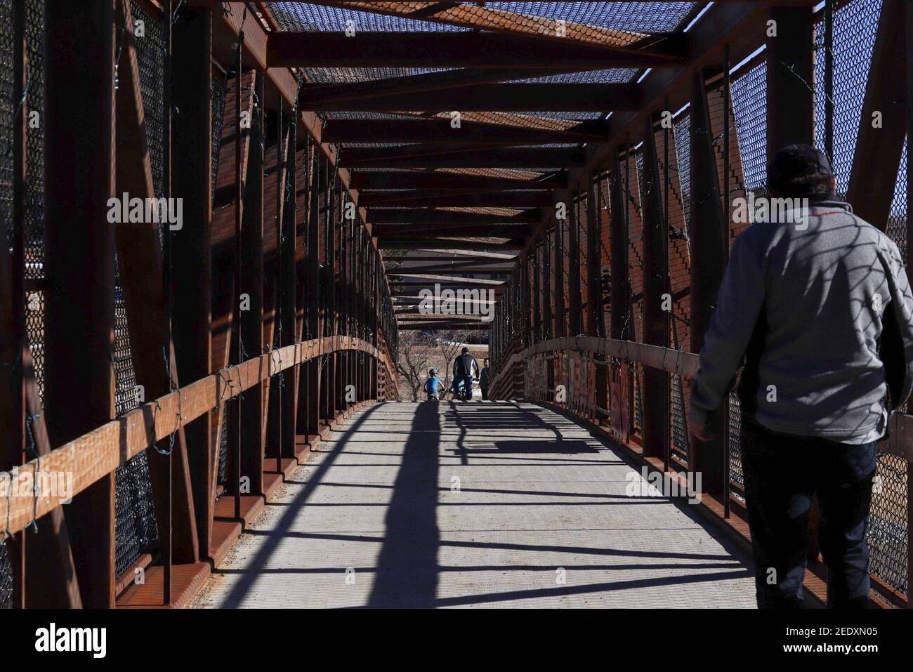 Back view of a male walking on a bridge Stock Photo - Alamy