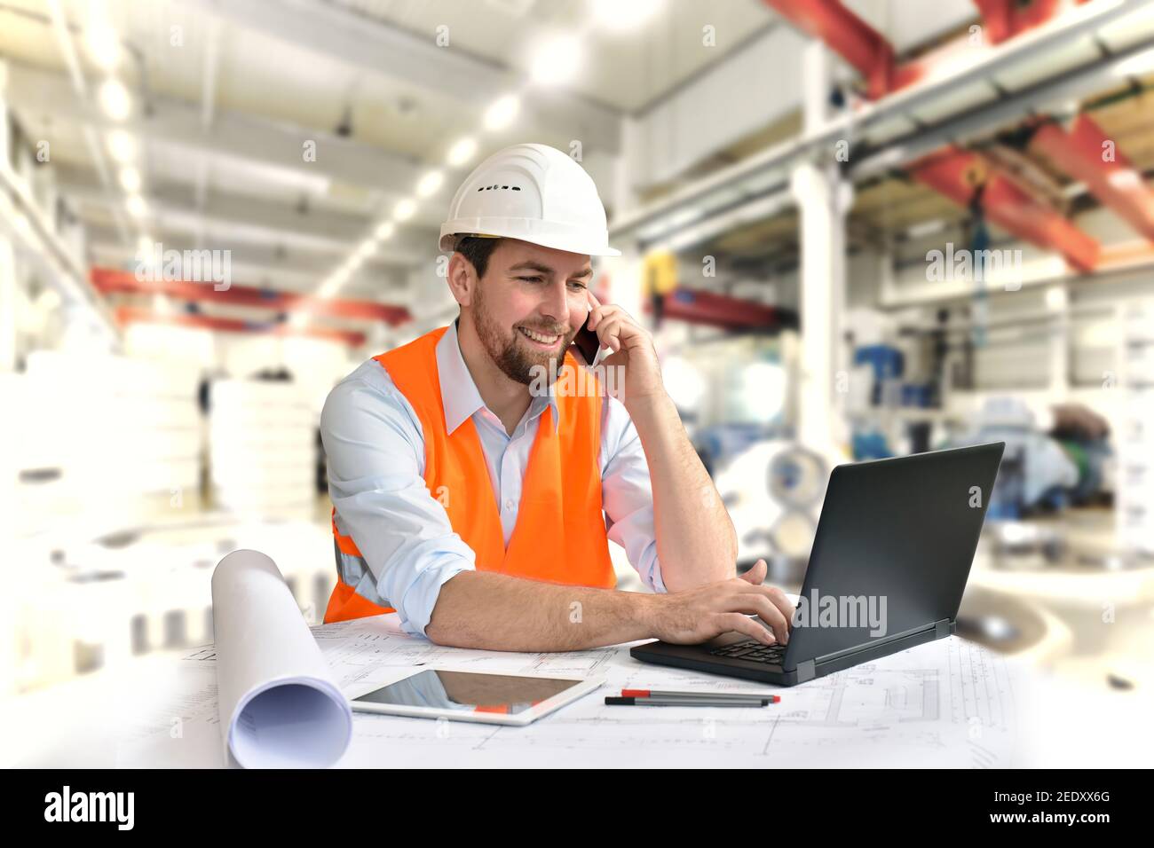 engineer at his workplace with notebook in an industrial company in mechanical engineering Stock Photo