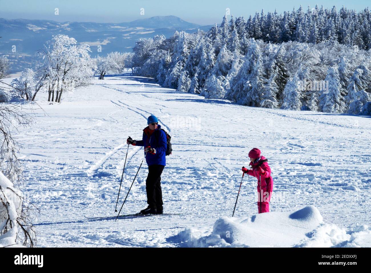 Father with daughter, Man child on a mountain meadow Cross country skiers winter scene Stock Photo