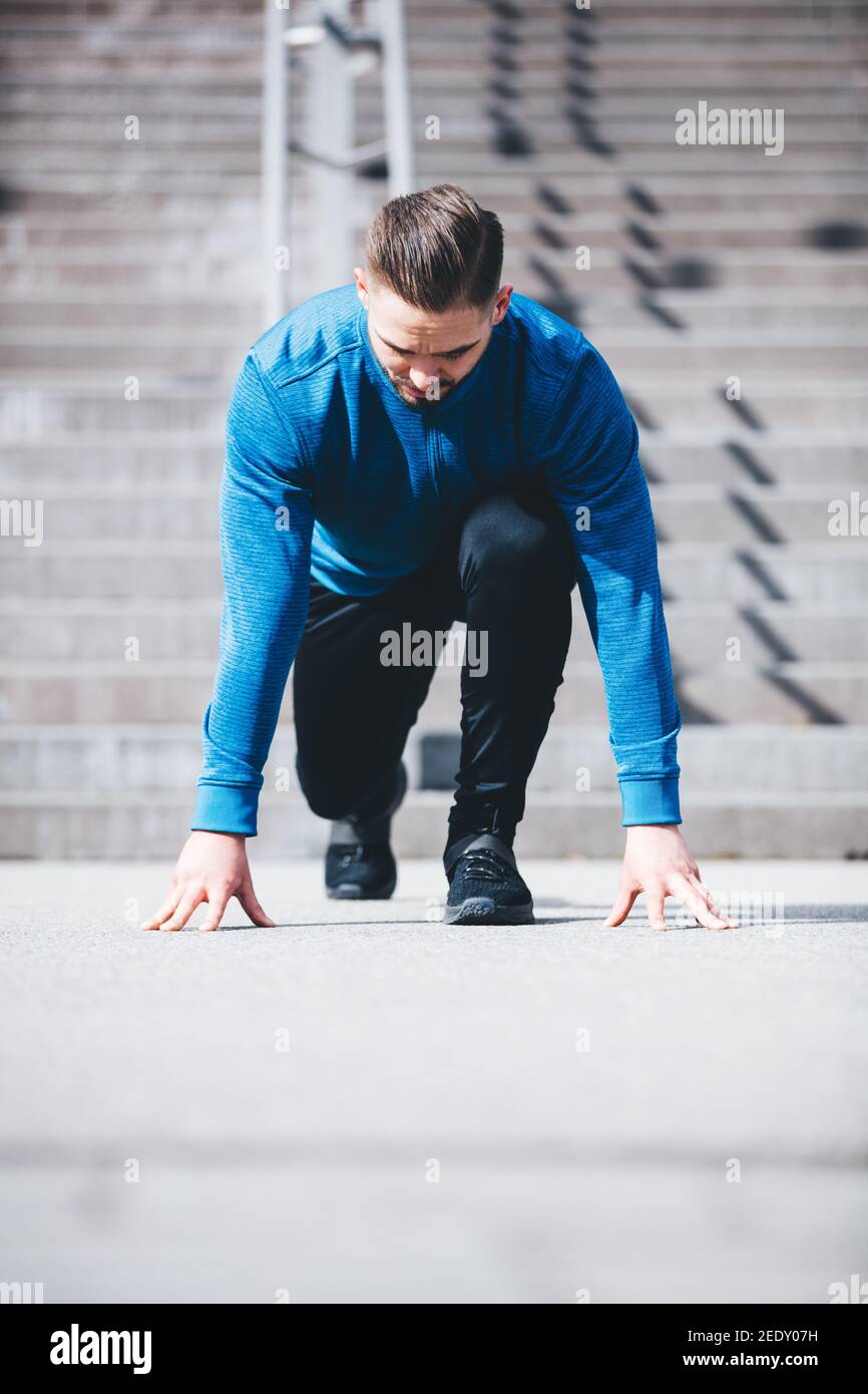 Man in sports clothes ready to run. Athlete. Fit lifestyle. Professional sportsman. Stock Photo