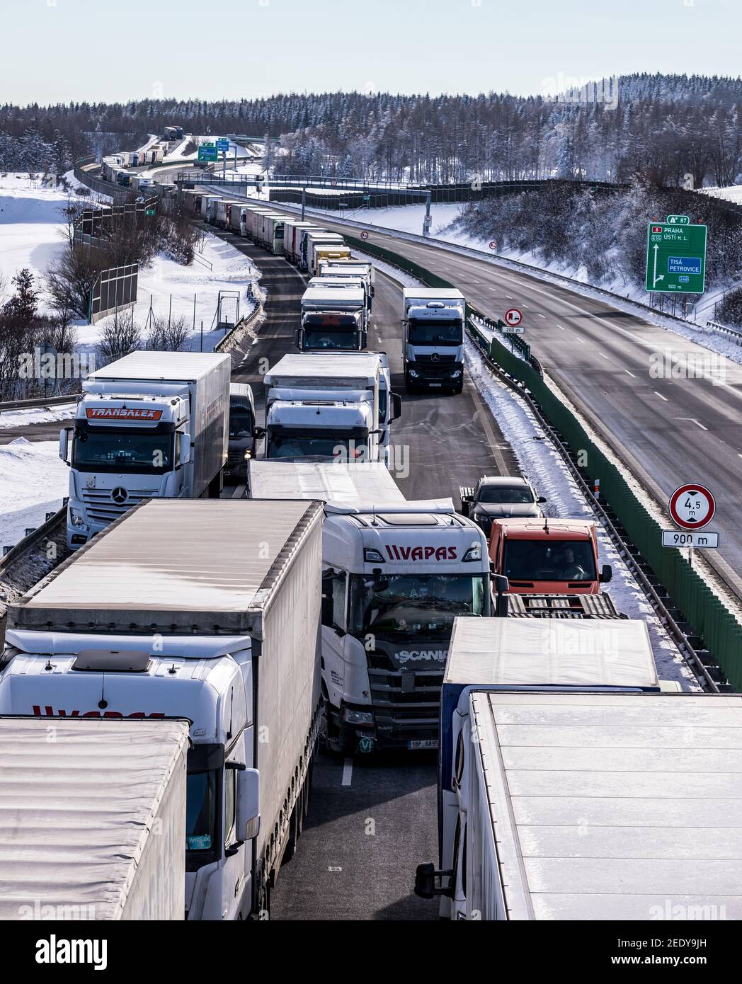 Petrovice, Czech Republic. 15th Feb, 2021. Trucks are jammed on the motorway D8 in front of the Czech-Germany border crossing in Petrovice, Czech Republic, February 15, 2021. The trucks are piling up due to border controls as part of efforts to curb the spread of the Coronavirus. Credit: Vojtech Hajek/CTK Photo/Alamy Live News Stock Photo