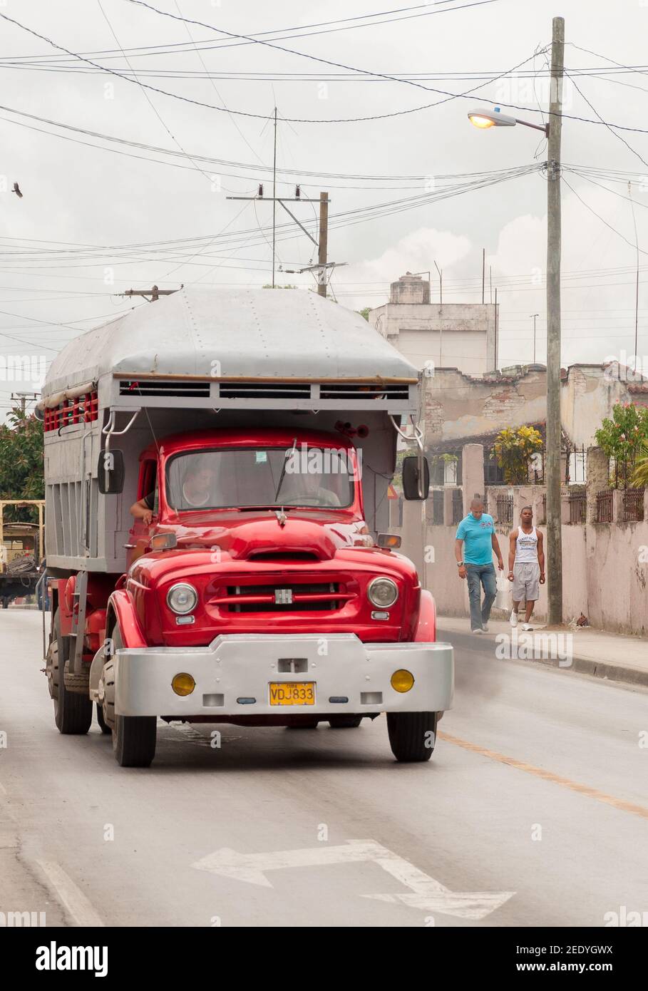 Old vintage American truck in Cuba: Red truck transporting cargo on a city street in the day Stock Photo