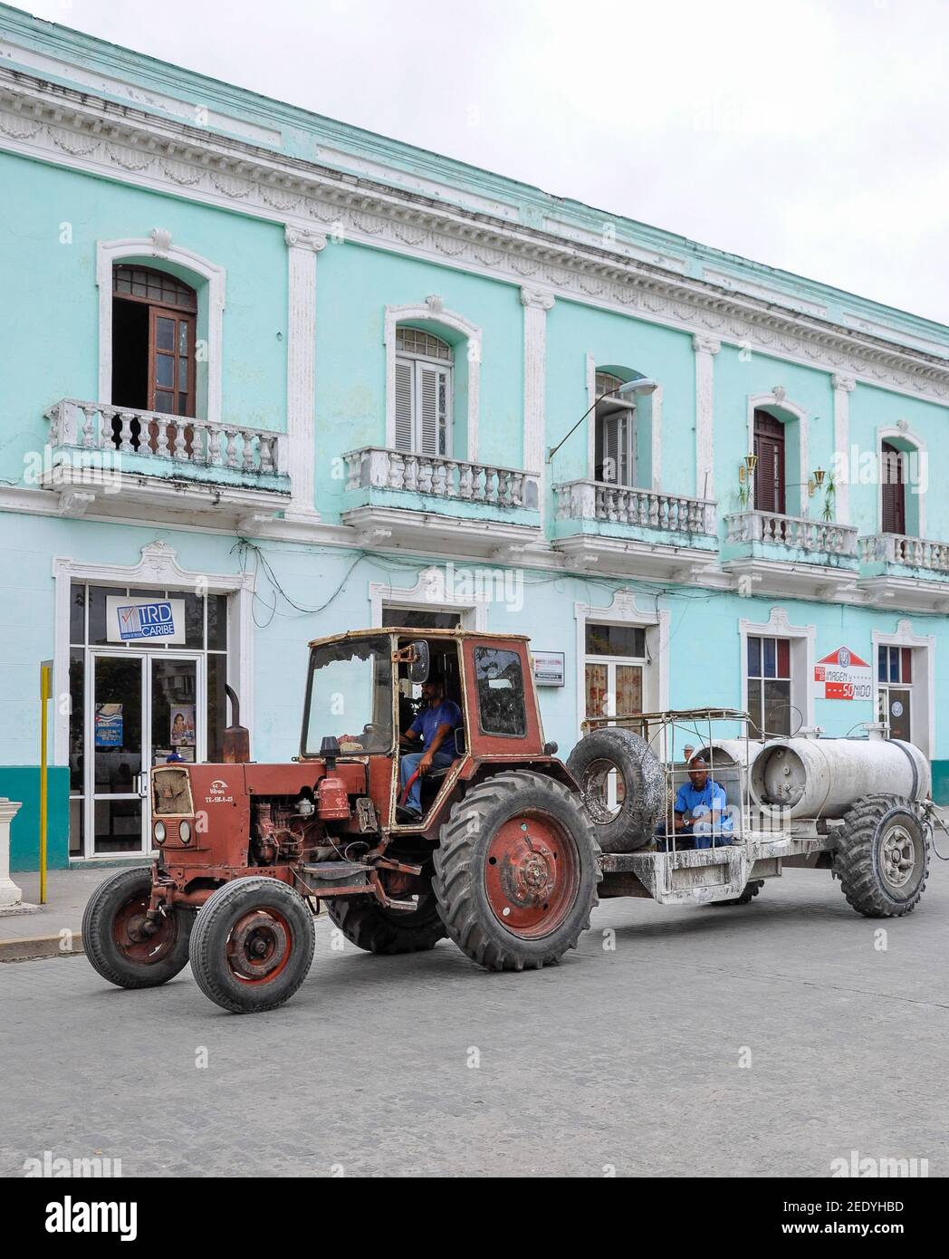 Cuban images: Old soviet tractor pulling a trailer on the street Cuban city Stock Photo