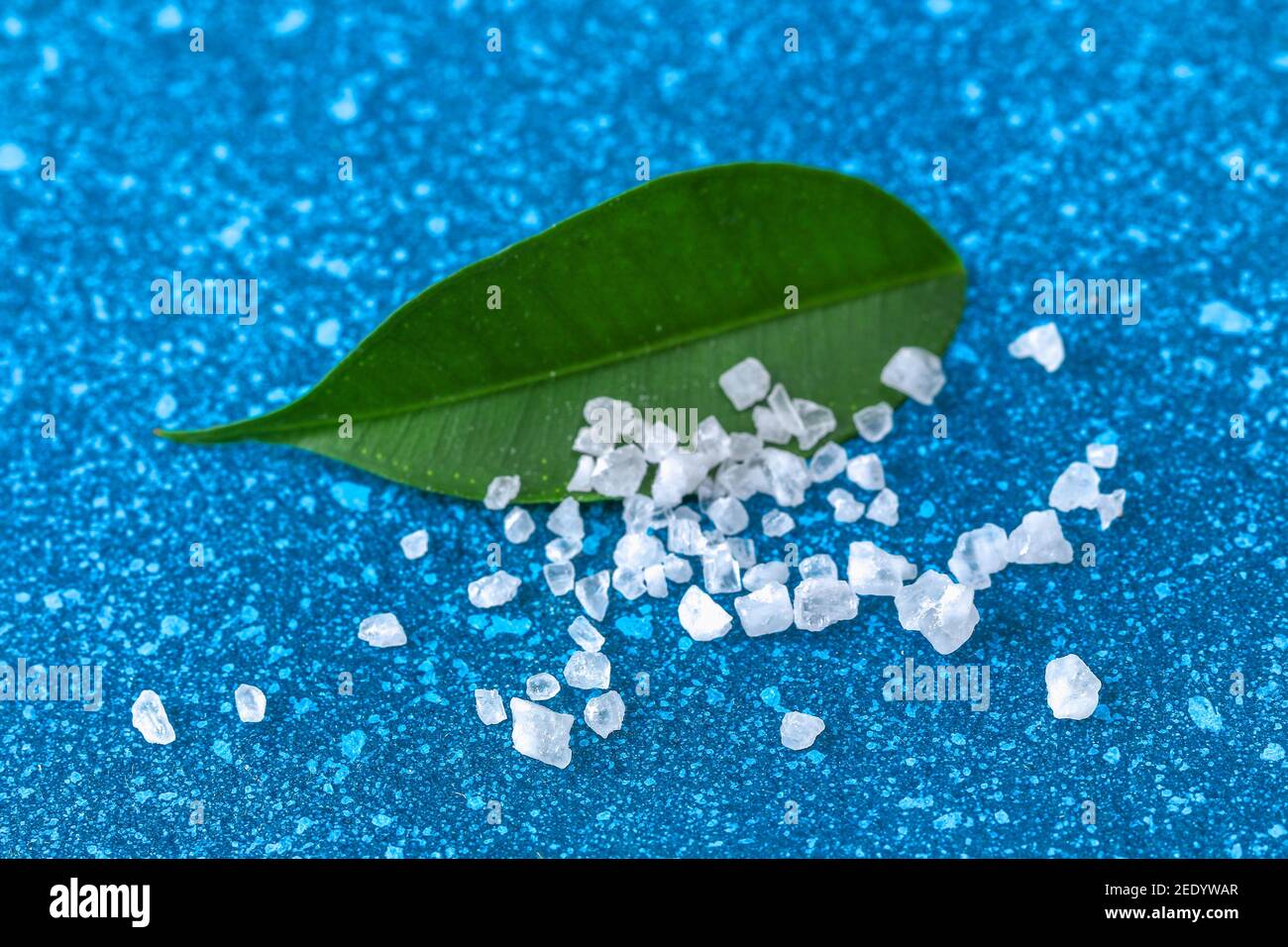 Coarse salt crystals on a blue table. sea salt. Background for