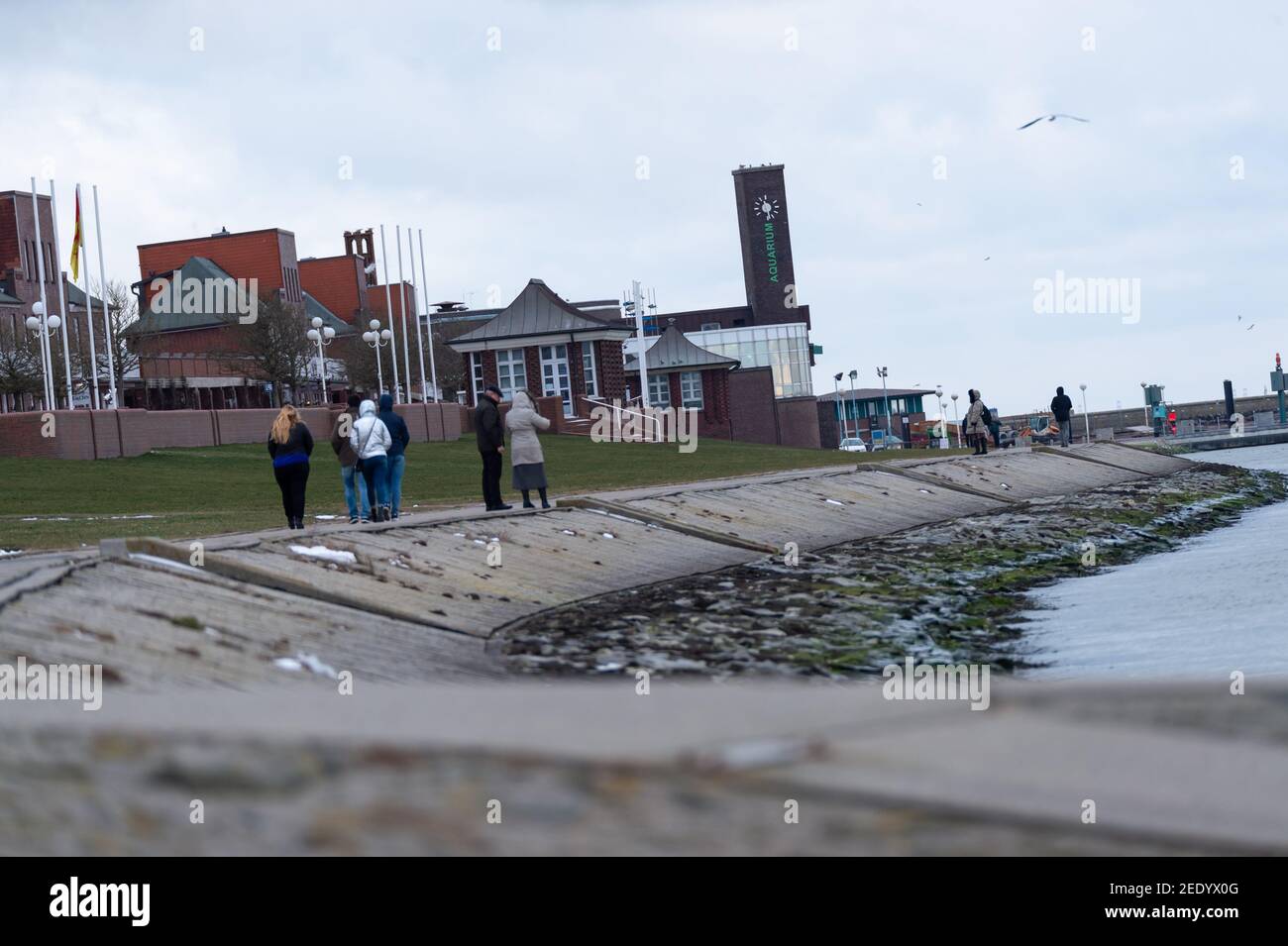 wilhelmshaven-germany-10th-feb-2021-strollers-under-grey-clouds-at