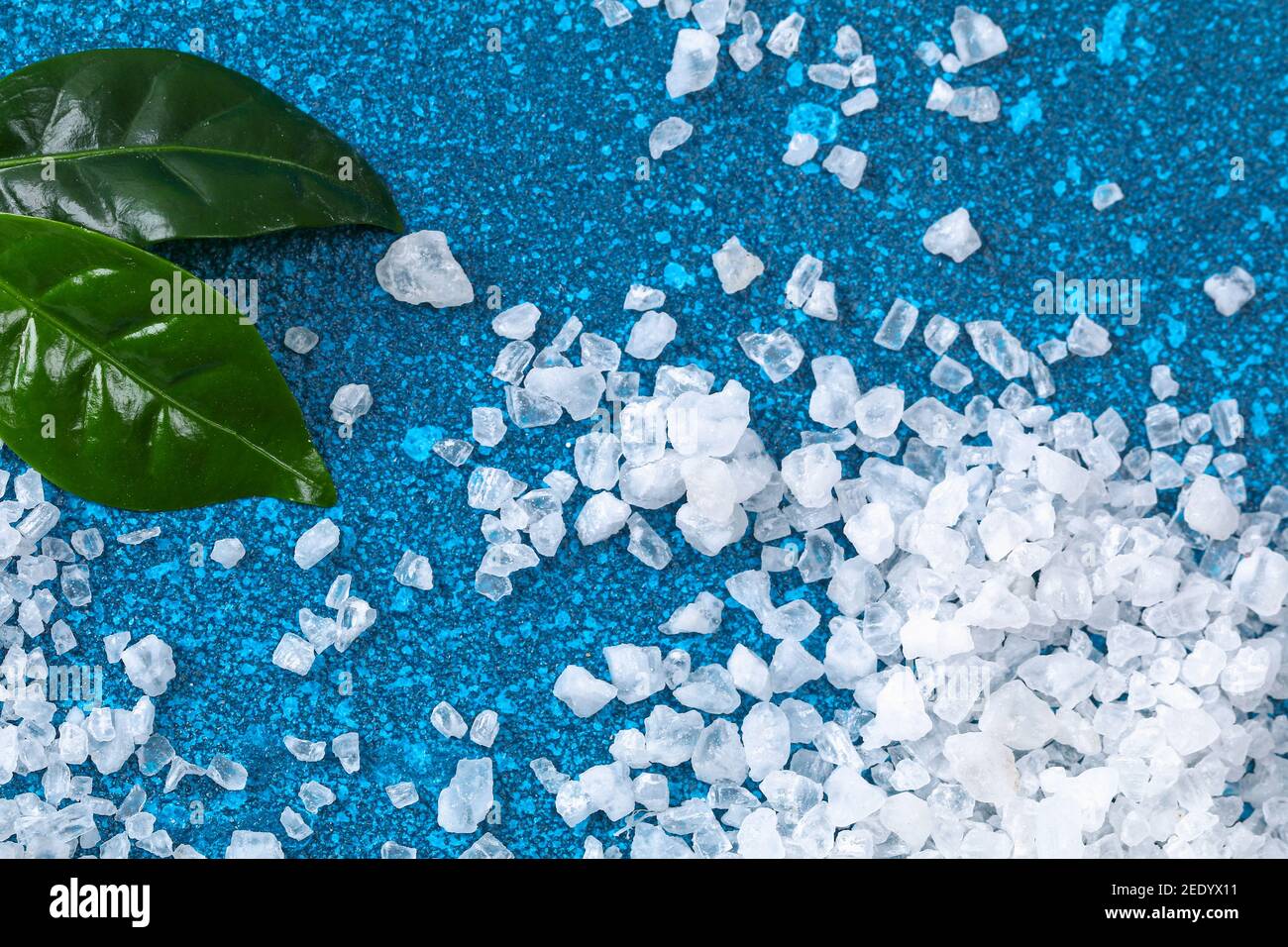 Coarse salt crystals on a blue table. sea salt. Background for