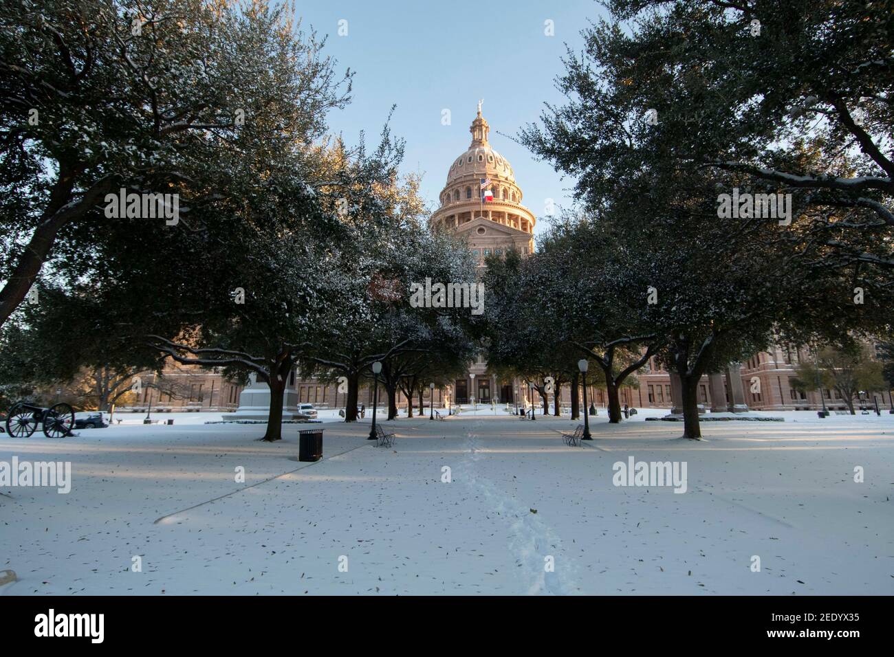 Austin, Texas USA Feb 15, 2021: The Texas Capitol grounds including the south walkway are covered in 6-7 inches of rare snowfall Monday morning after an overnight winter storm blew into central Texas. The accompanying frigid weather wreaked havoc on the state's electricity grid, causing massive power outages to millions of customers across the state. Credit: Bob Daemmrich/Alamy Live News Stock Photo