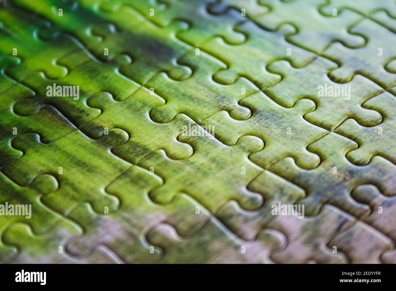 Jigsaw puzzle. Closeup of green jigsaw puzzle peices. Conceptual photo with focus on completed puzzle Stock Photo