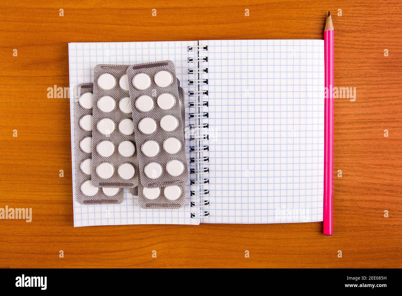 Writing Pad and the Pills on the Wooden Table closeup Stock Photo