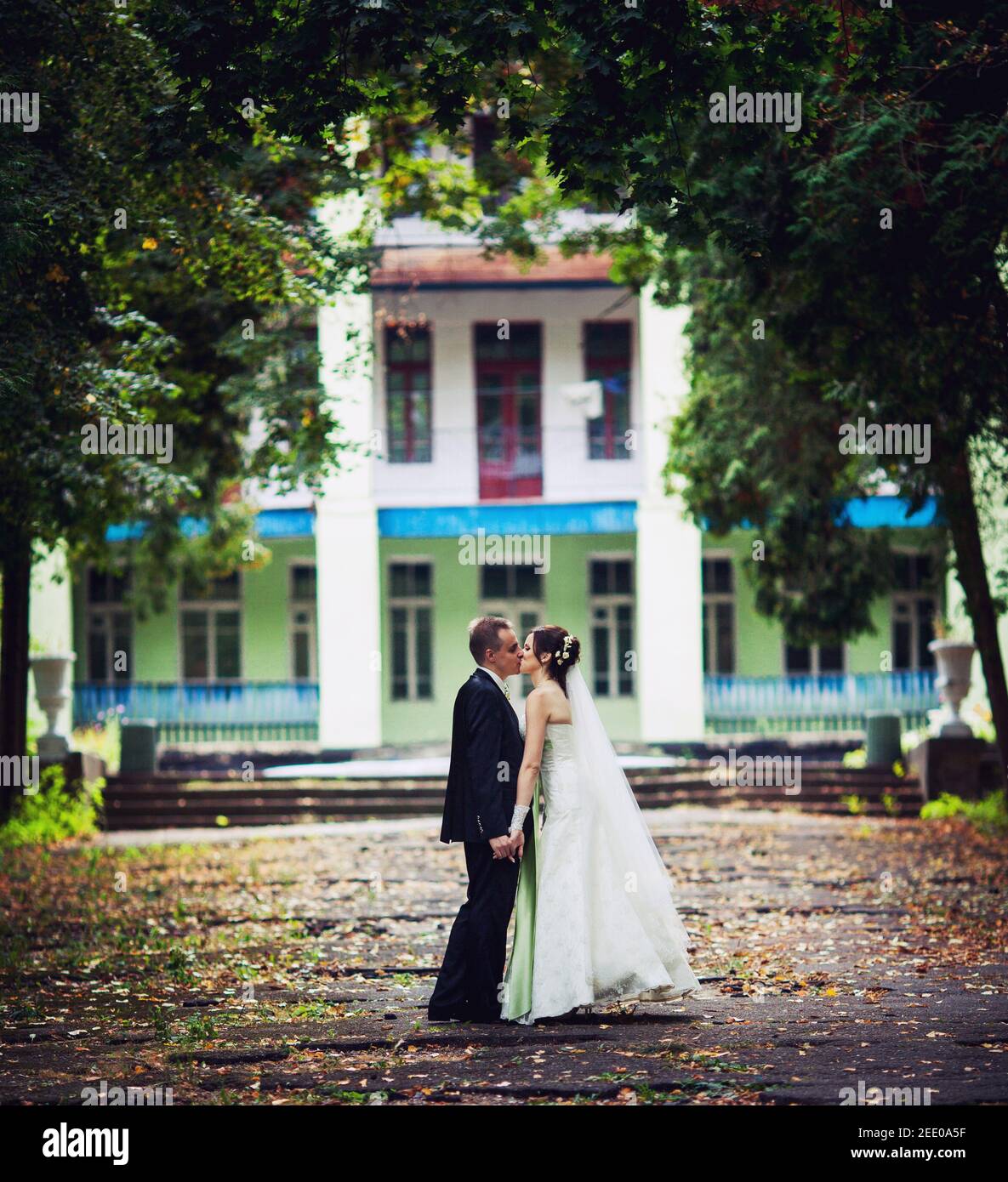 Walk young bride and groom on old house background Stock Photo - Alamy
