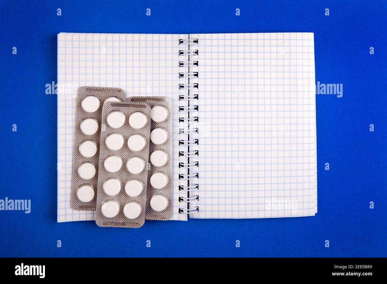 Writing Pad and the Pills on the Blue Paper closeup Stock Photo