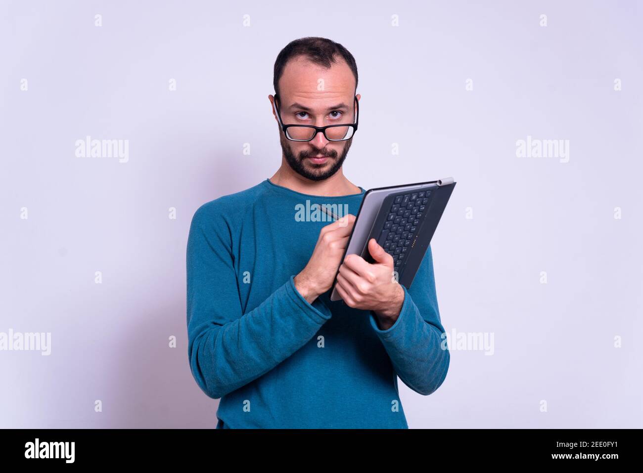man using ipad or tablet on white background with glasses with casual clothes. account or office worker Stock Photo