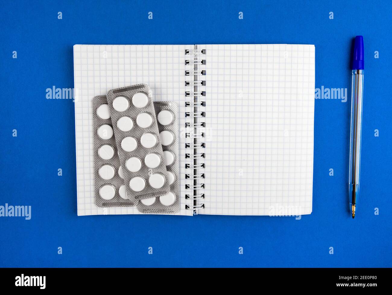 Writing Pad and the Pills on the Blue Paper closeup Stock Photo