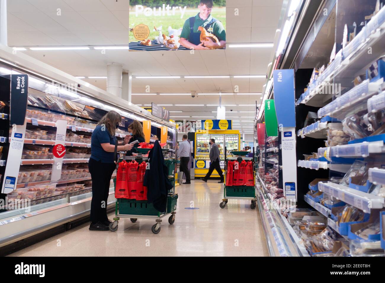 Ashford, Kent, UK. 15th Feb, 2021. Tesco supermarket workers fulfilling online food orders by picking items from the poultry aisle shelves in Ashford, Kent. Photo Credit: Alamy Live News Stock Photo