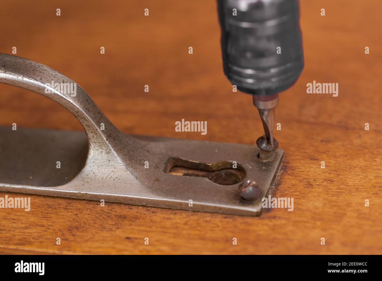 Removing slotted screw and handle on old wooden cupboard door for