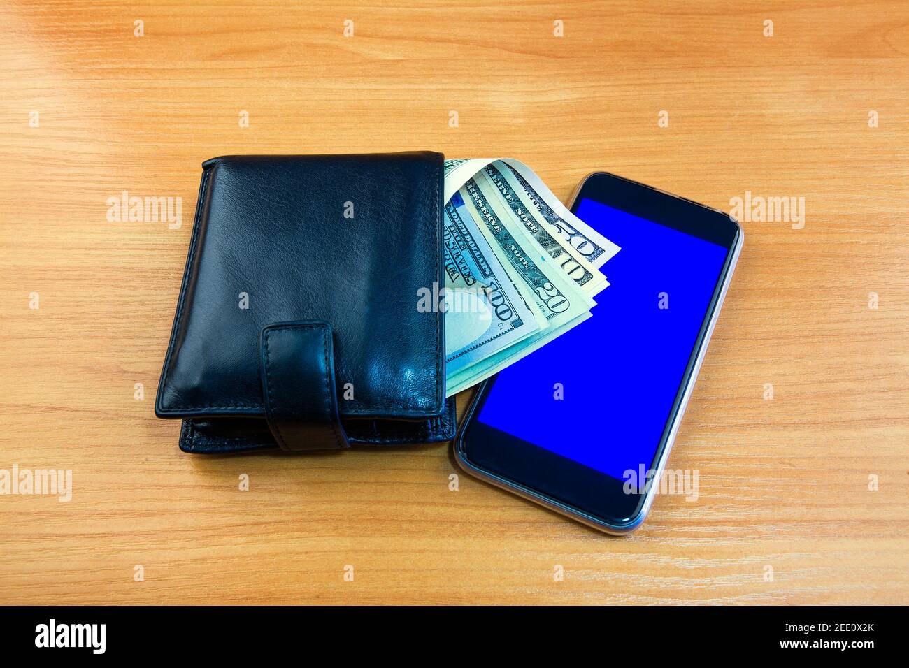 Money in the Wallet and Mobile Phone on the Wooden Table closeup Stock Photo