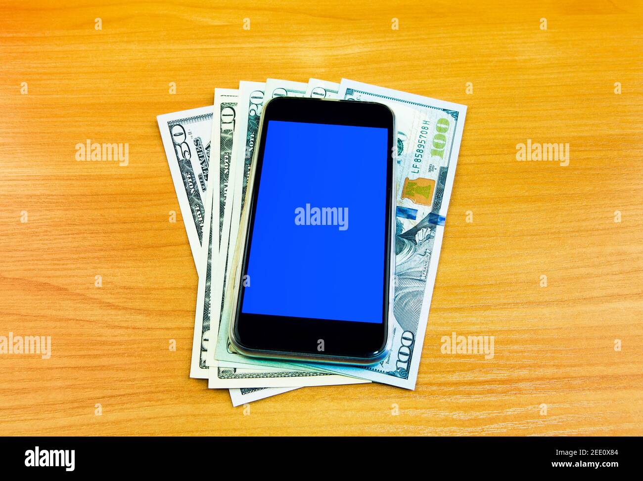 Money and Mobile Phone on the Wooden Table closeup Stock Photo