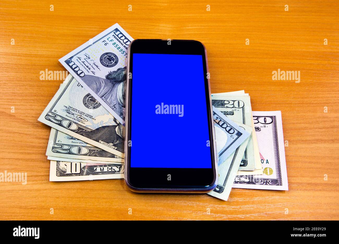 American Dollars and Mobile Phone on the Wooden Table closeup Stock Photo