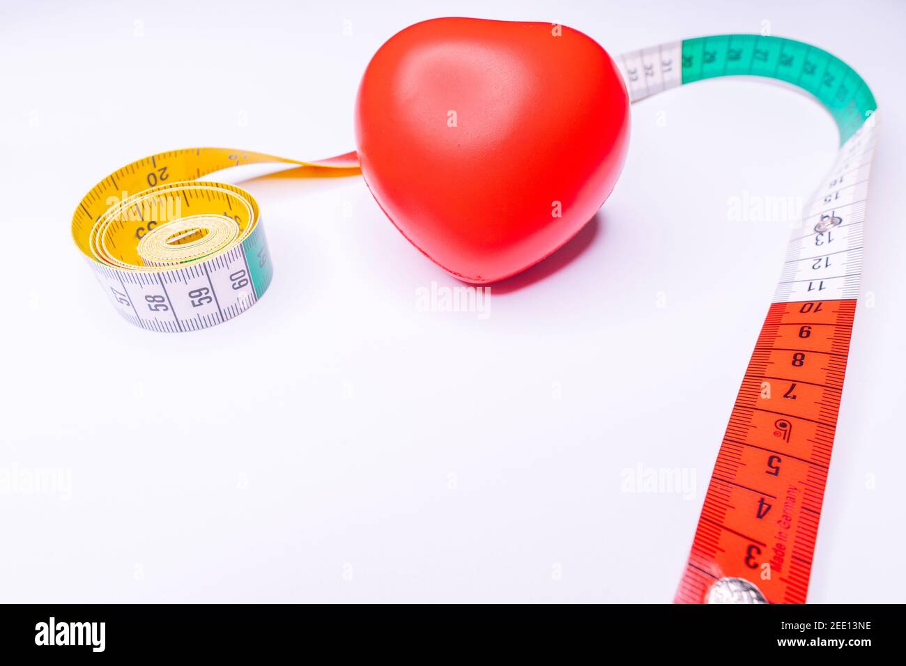 Top view red heart shape and white measurement tape on white background ...