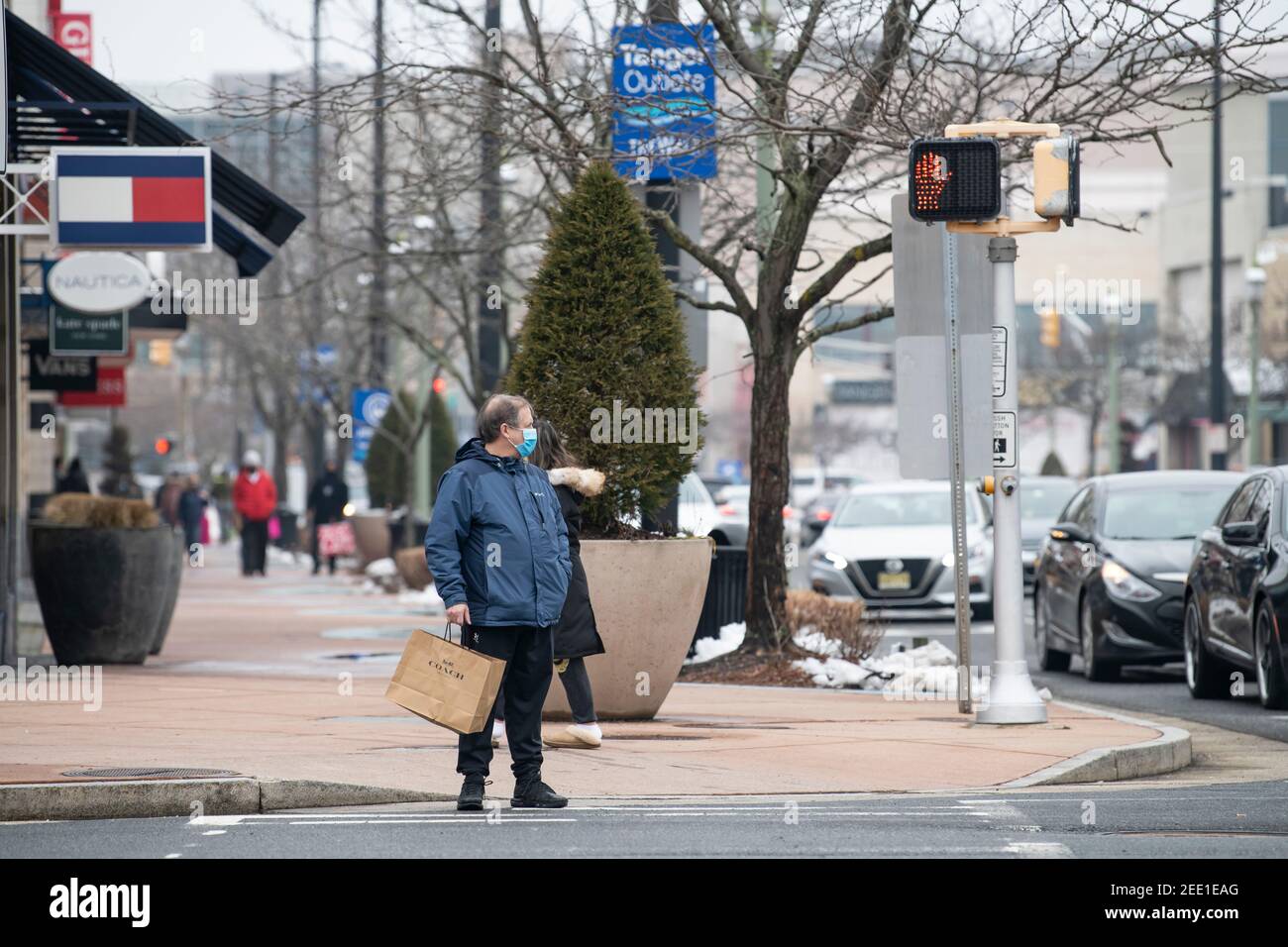 Atlantic City, New Jersey, USA. 14th Feb, 2021. A man carries a Coach shopping bag while wearing a PPE mask at The Tanger Outlet Mall in Atlantic City, New Jersey. Mandatory credit: Kostas Lymperopoulos/CSM/Alamy Live News Stock Photo