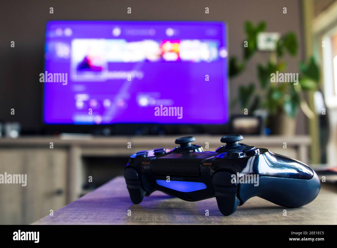 A Closeup Portrait Of A Sony Playstation 4 Controller In Front Of A Television With The Playstation Home Menu Displayed On It The Ps4 Video Game Cont Stock Photo Alamy