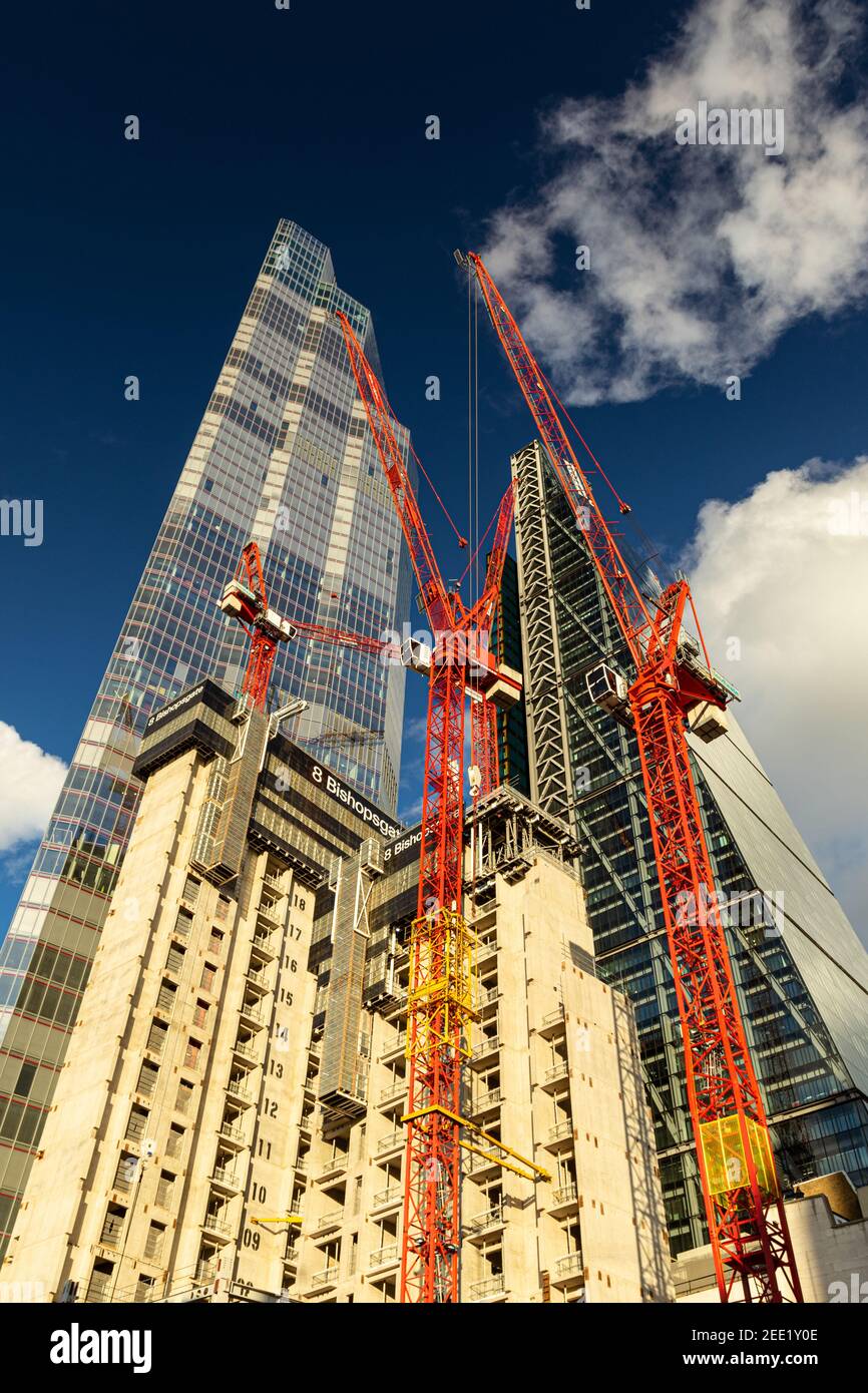 Looking up at construction work of 8 Bishopsgate with skyscraper 22 bishopsgate towering into the sky against a deep blue sky with fluffy clouds - Stock Image