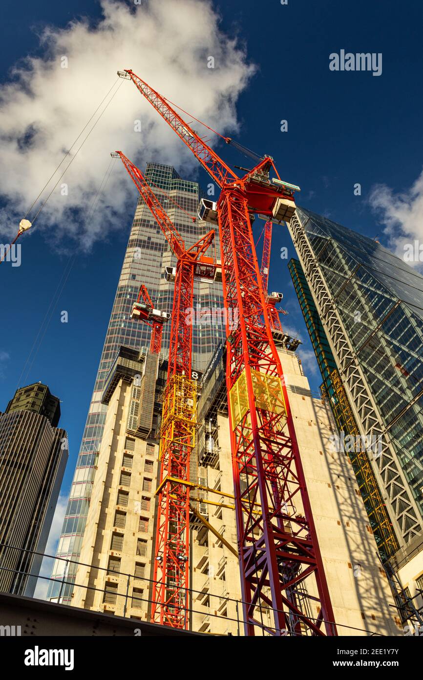 Looking up at construction work of 8 Bishopsgate with skyscraper 22 bishopsgate towering into the sky against a deep blue sky with fluffy clouds - Stock Image