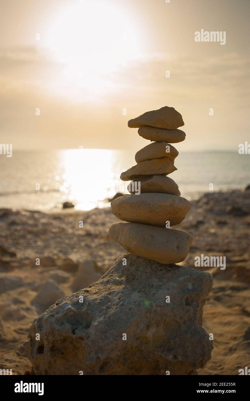 Pebble stack on beach at sunset, Playa de ses illetes, Formentera, Balearics, Spain Stock Photo