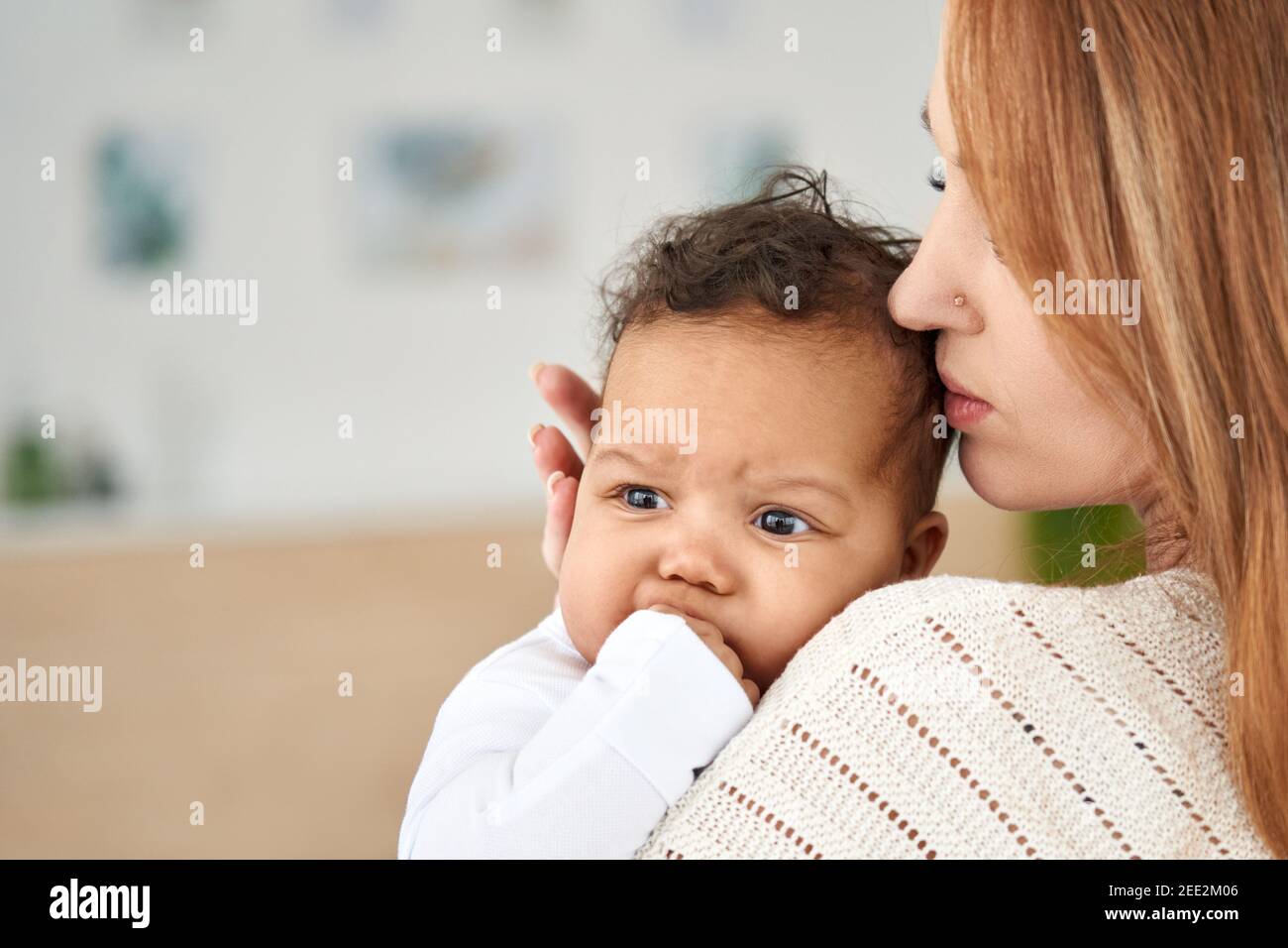 Loving young mother soothing cute infant baby girl teething biting hand Stock Photo Alamy