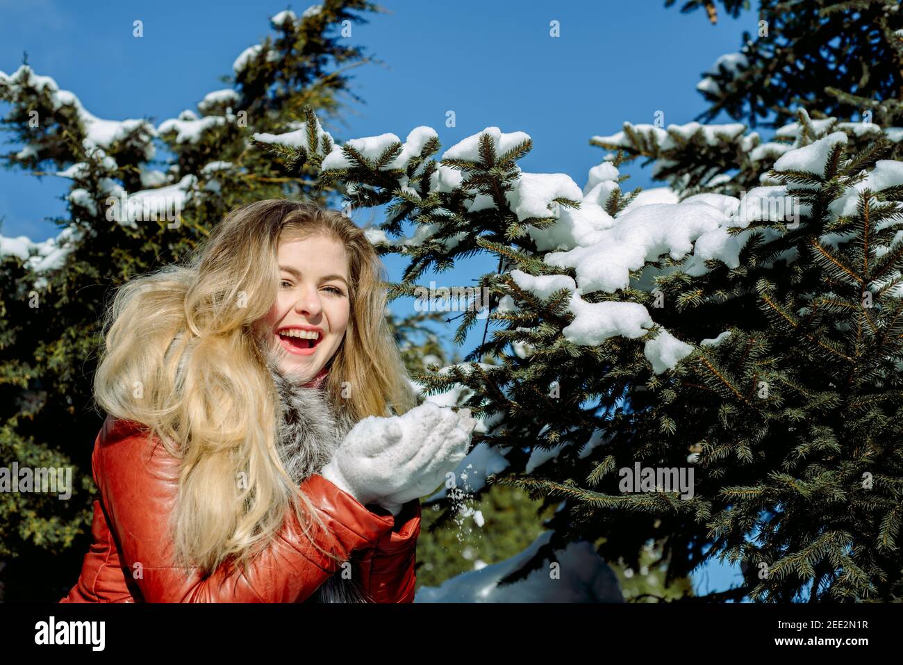 Emotional blue-eyed girl blowing snow in her hands. Frosty winter. Stock Photo