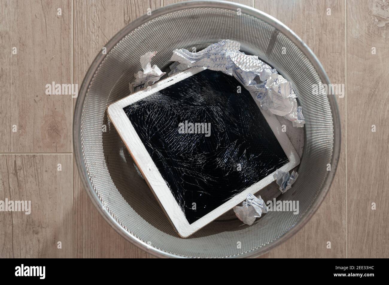 Modern tablet with highly broken screen in the litter bin. Top view. Stock Photo