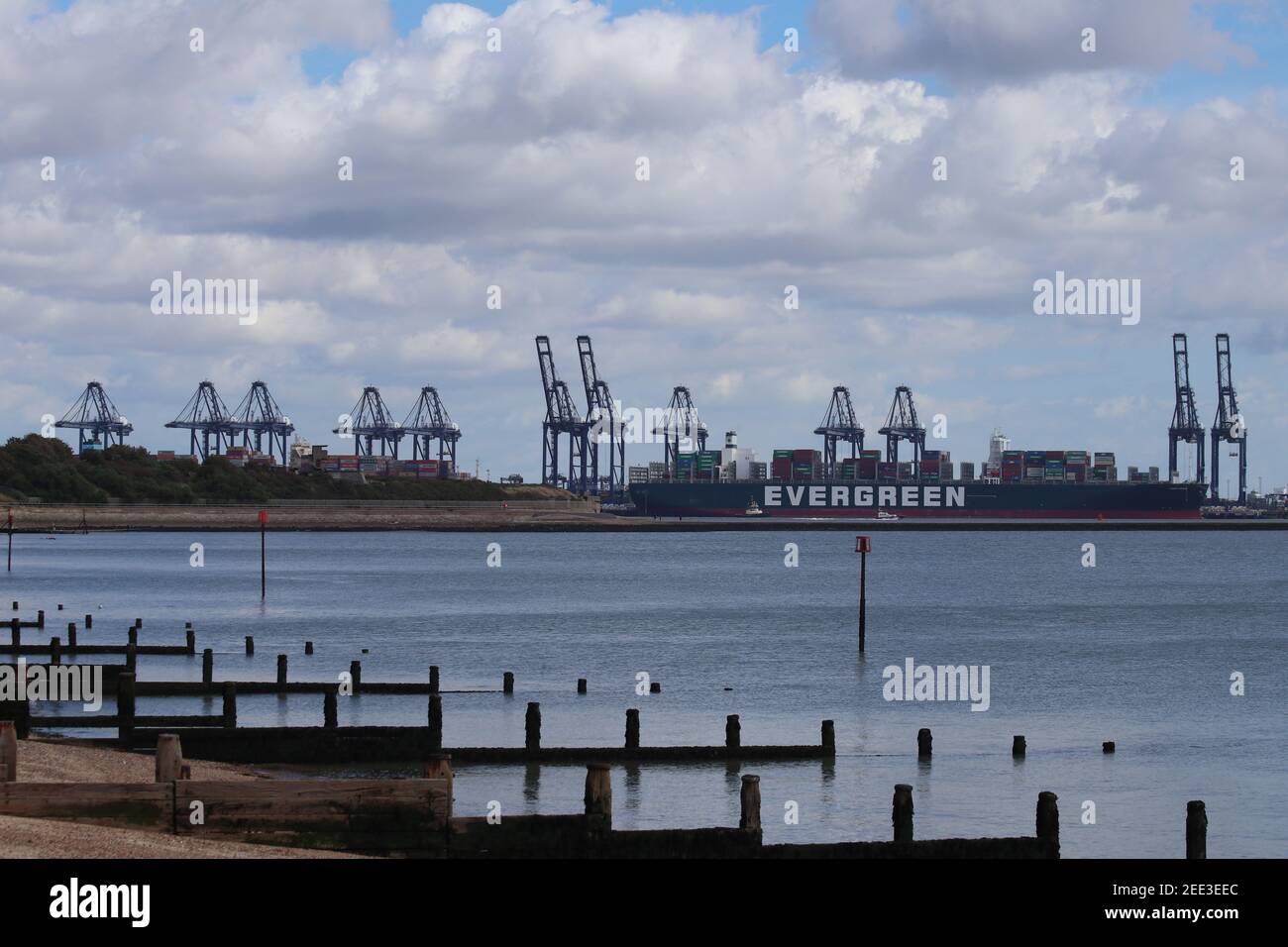 Harwich docks and Evergreen cargo ship seen from Dovercourt Bay Stock