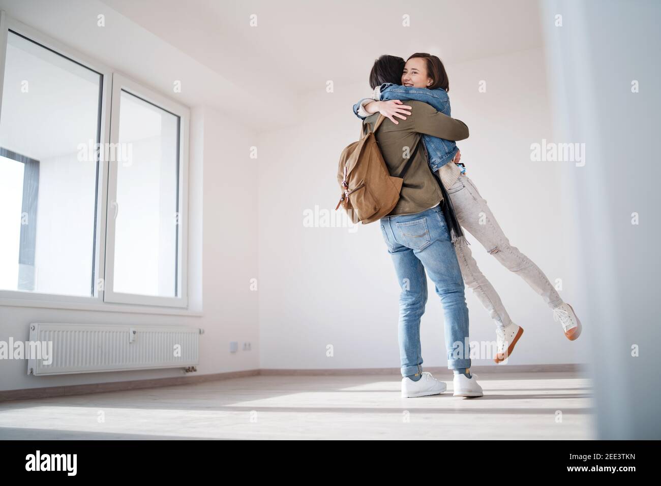 Young couple owners hugging in new flat, moving in, new home and ...