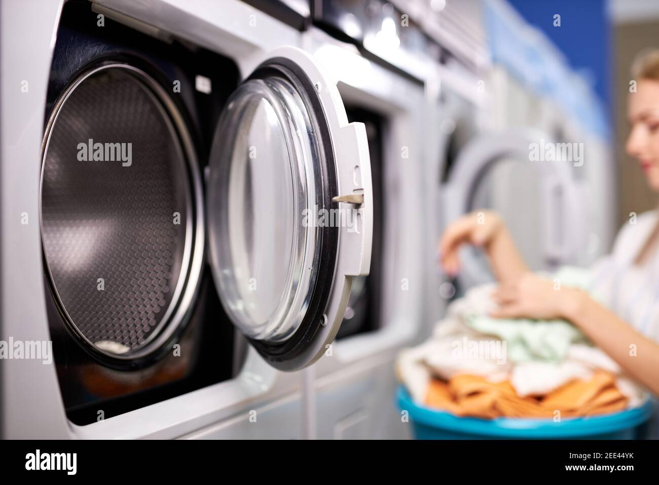 woman in washing house sorting clean clothes, doing household duties