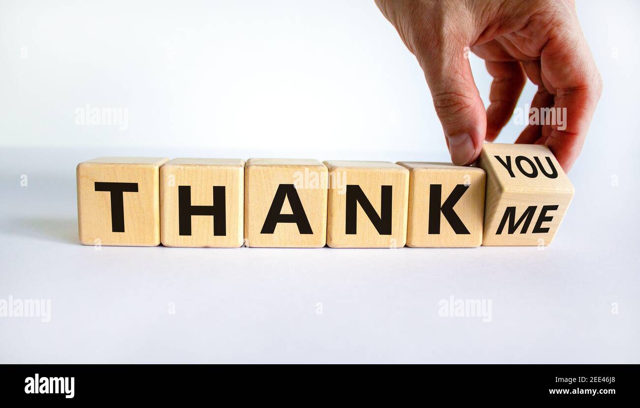 Thank you or me symbol. Businessman turns a cube and changes words 'thank me' to 'thank you'. Beautiful white background, copy space. Business, psycho Stock Photo