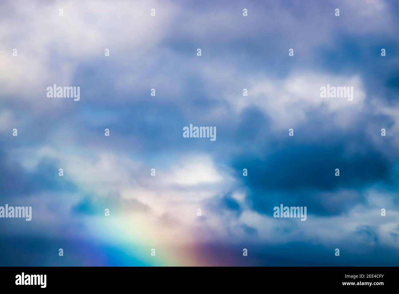 Clouds and rainbow fill close up image of tropical sky for background texture. Stock Photo