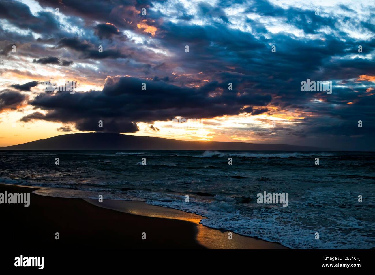 Dramatic clouds and sky over stormy sea at sunset with island on horizon. Stock Photo