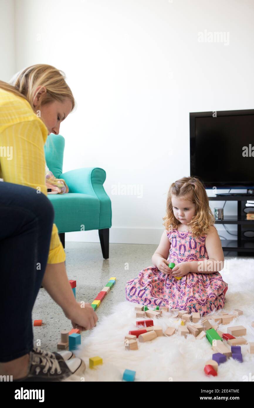 Mom and little girl playing with toys at home. Stock Photo