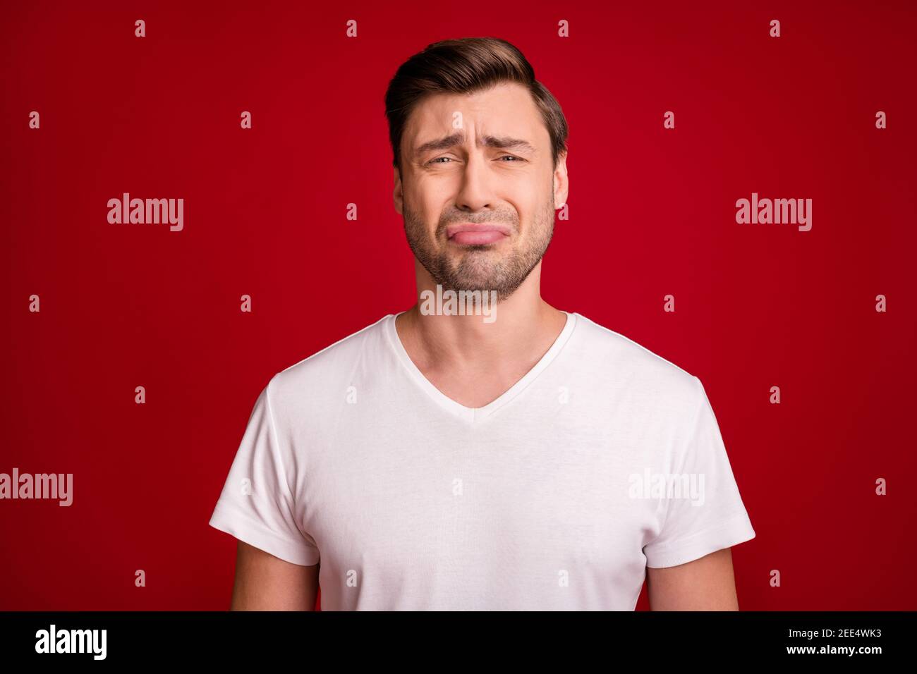 Photo portrait of sad guy crying unhappy grumpy bad mood isolated vivid red color background Stock Photo